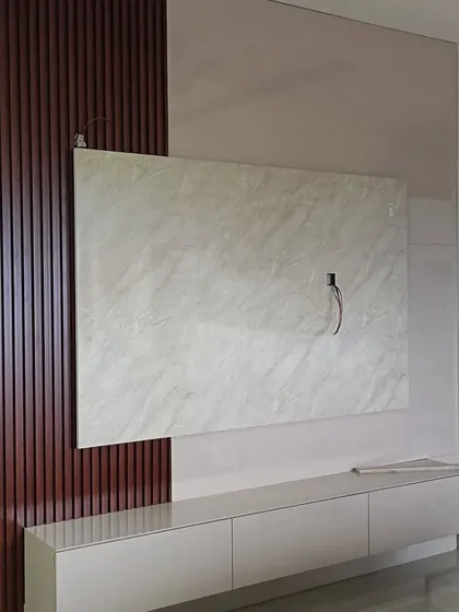 A functional TV unit with a marble backdrop and wood-paneled accent. The floating console keeps the design light and modern, adding value to the living room's overall look.