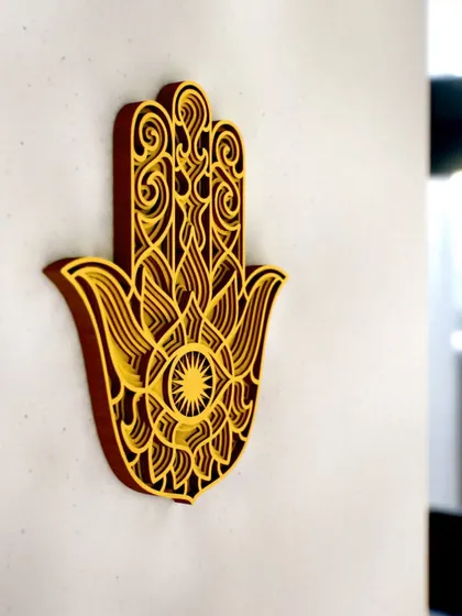 The Hamsa Hand, a symbol of protection and blessings, is beautifully rendered in this 3D layered wood art. The warm yellow and brown tones create a welcoming and positive energy.