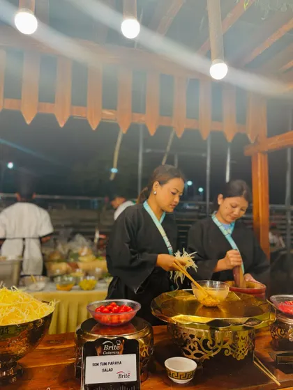 My staff preparing fresh papaya salad at the Thai station, demonstrating the use of authentic techniques.