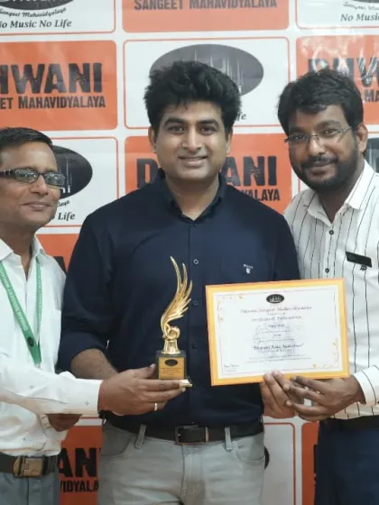 A teacher presents an award to his student, recognizing his hard work.