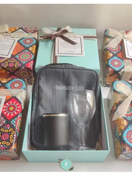 This employee promotion hamper includes a mix of practical items like a travel pouch, a wine glass, and a thermal mug. The gifts are presented in our signature teal box with colorful wrapping, making the recognition feel extra special.