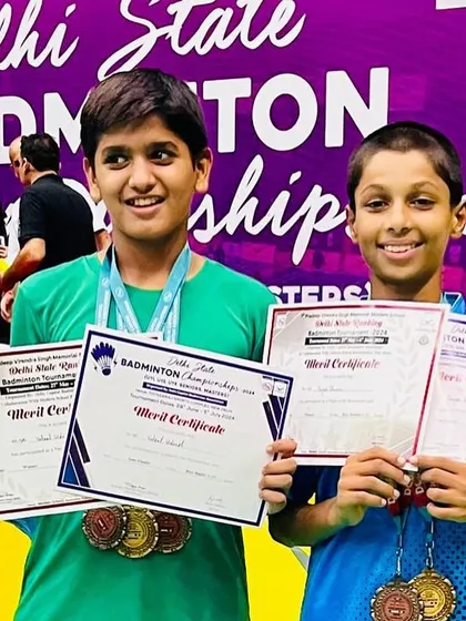 A close-up of our U-13 champions, Vatsal and Rajas, proudly displaying their medals and merit certificates after a successful run at the Delhi State Badminton Championship.