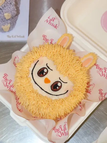 Another surprise from our Labubu mystery lunchbox cake collection. This orange character has such a sweet and shy expression, created with detailed black and white icing.