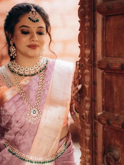 A close-up portrait of the bride by a carved wooden door. The warm tones and soft light create a very classic and elegant feel.