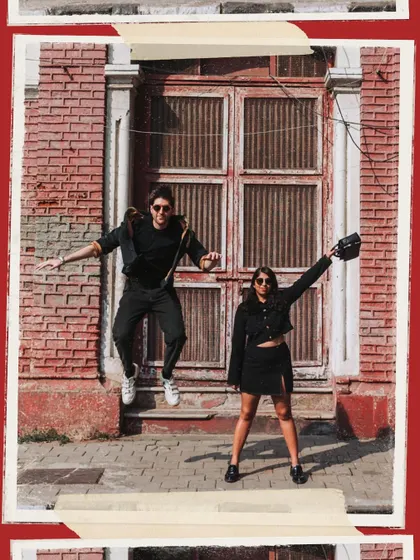 A playful jump in front of a vibrant red brick wall at Mumbai Samachar. This shot is all about capturing the fun and spontaneous side of a couple's personality.