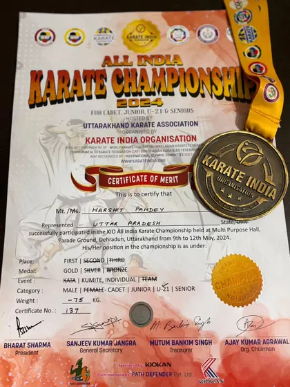 A close-up of the gold medal and certificate from the All India Karate Championship, awarded to Harshit Pandey for winning the U21 event.