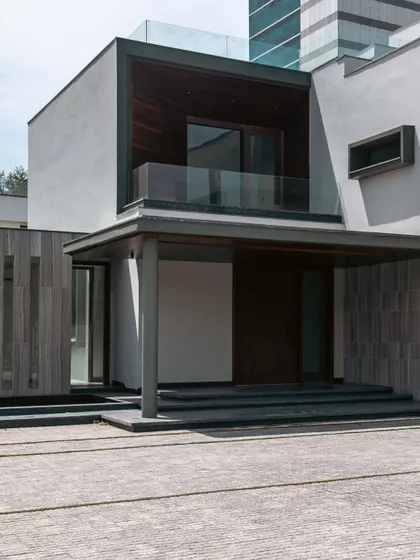 The entrance porch at Rosewood Farmhouse is marked by a large canopy that provides shelter and adds architectural drama. The steps leading up to the entrance create a sense of elevation and formality, setting the stage for the home within.