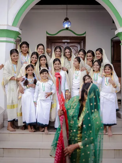 The bride, surrounded by her smiling relatives, is the center of attention in this happy moment from the Arikuth ceremony.