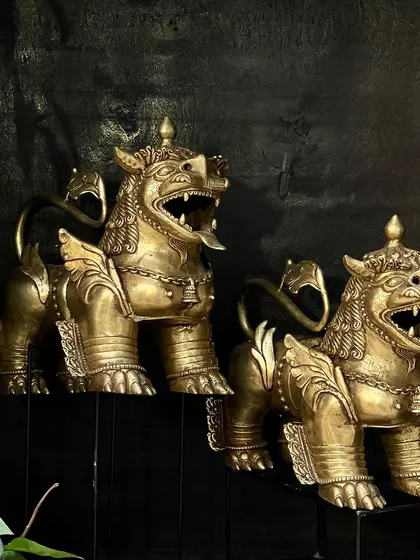 Another view of the Tibetan temple lions, handcrafted from brass. These guardians of the abode are designed to keep evil at bay, making them a meaningful and artistic addition to your decor.