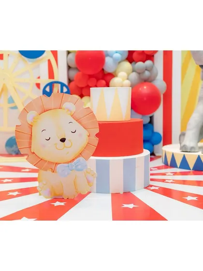 An adorable lion cub prop sits in front of a red-and-white striped floor, adding a cute touch to our circus theme.