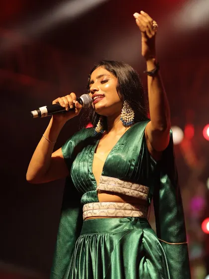 A final powerful pose from the performance. The large statement earrings complete this glamorous fusion look.