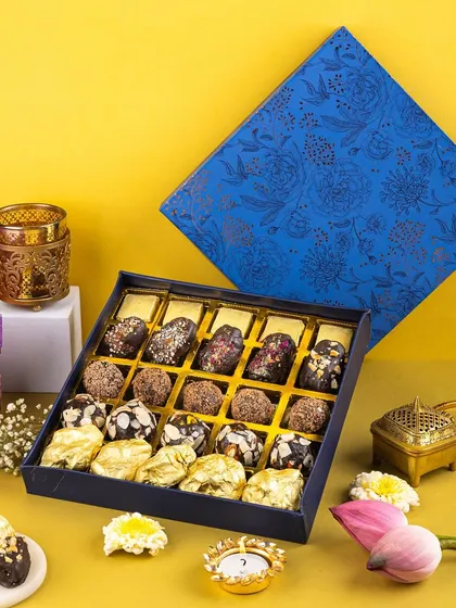 A vibrant, high-contrast shot of a Diwali sweet box, using a bold yellow and blue palette to grab attention on social media feeds.