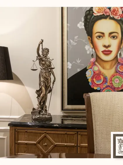 This sculpture of Lady Justice is a powerful symbol of fairness and integrity, making it an ideal piece for a home office or study. It is paired here with a vibrant Frida Kahlo portrait, creating a bold contrast of styles.