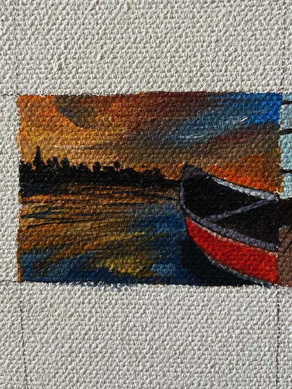 A mini-painting of a boat docked at sunset.