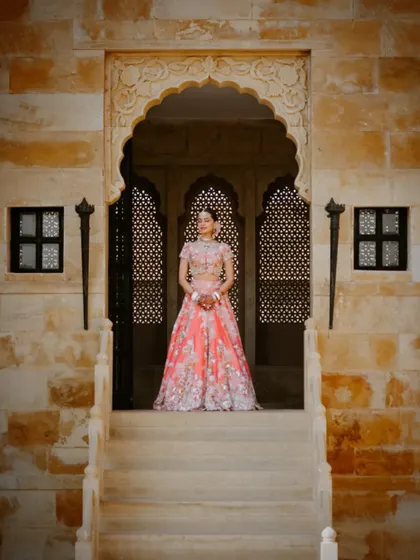 A full-length shot of the bride framed by a traditional Rajasthani archway, creating a majestic portrait.