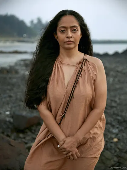 A straight-on portrait that captures her strength and soulful gaze. The wildness of her hair and the rugged background feel harmonious and authentic.