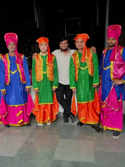 Posing with dancers in traditional Bhangra attire for a corporate event. I can arrange for a wide variety of dance styles and costumes, including folk and regional performances.
