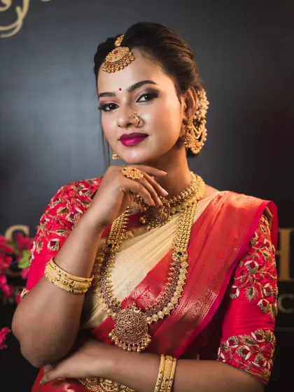 A classic red and gold bridal blouse featuring floral maggam work. This design is a favorite among brides for its traditional elegance and rich detailing.
