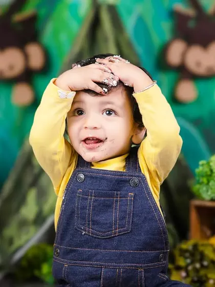 Oh, the mess! This baby boy has frosting all over his hands and head, and he couldn't be happier about it.