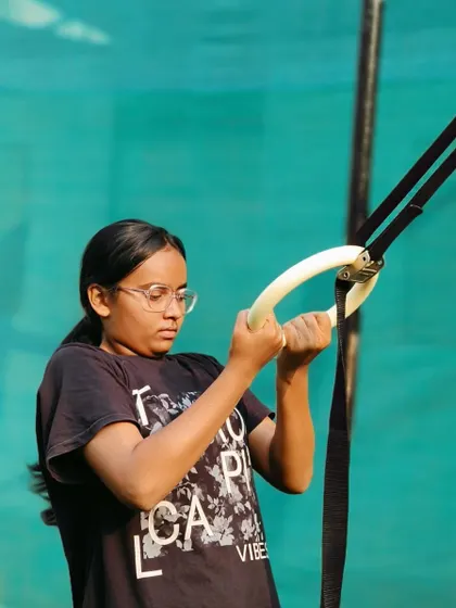 Focused and ready. This athlete is preparing for a set on the rings, a versatile tool for building a strong upper body.