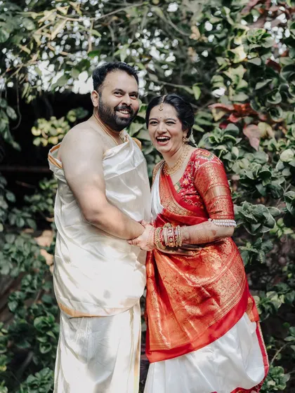 A candid moment of laughter between a couple in their traditional wedding attire. This photo captures the genuine happiness and easy chemistry that makes their relationship special.