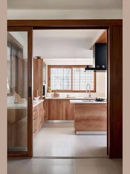 A view into the kitchen from the family lounge, showing the open and functional layout. The utility balcony was integrated into the kitchen to create one large, seamless space for cooking and family interaction.