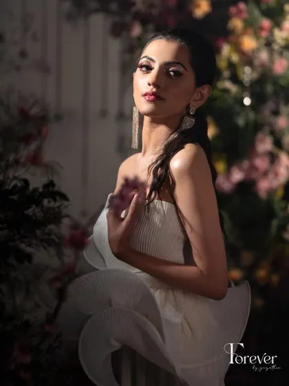 Another shot from a creative photoshoot, this time with dramatic lighting. This look showcases a soft, ethereal glam with a focus on glowing skin and defined eyes, perfect for a modern party or event.