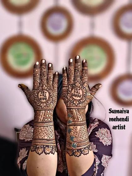 A lovely shot of a 'Dad to be' and 'Mom to be' henna design for a baby shower.