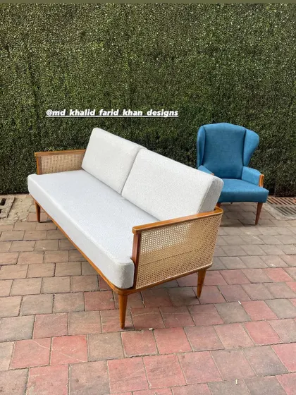 Another view of the cane-backed sofa, showing its sleek profile from the side.