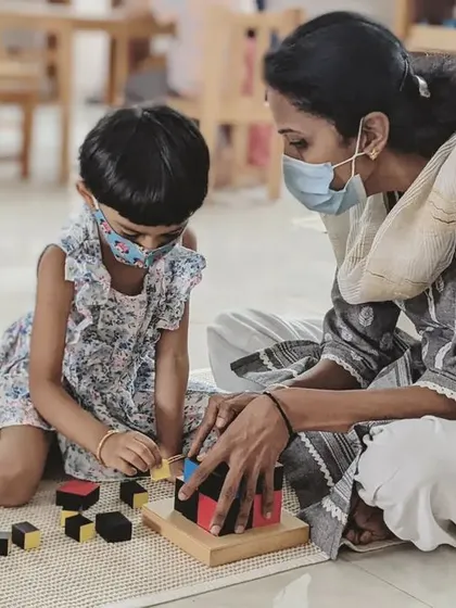 A teacher provides one-on-one guidance as a child works with the Trinomial Cube. Your training will focus on this art of observation and knowing exactly when to step in to offer support, and when to step back to allow for independent discovery.