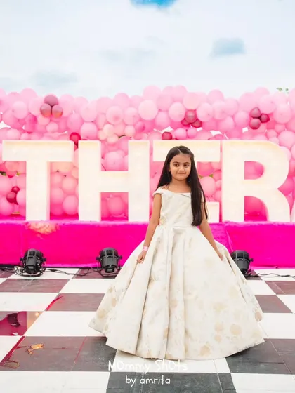 Here is the birthday princess herself, dressed in a beautiful ball gown in front of a custom backdrop with her name in marquee letters. I work to make every child the star of their own party.