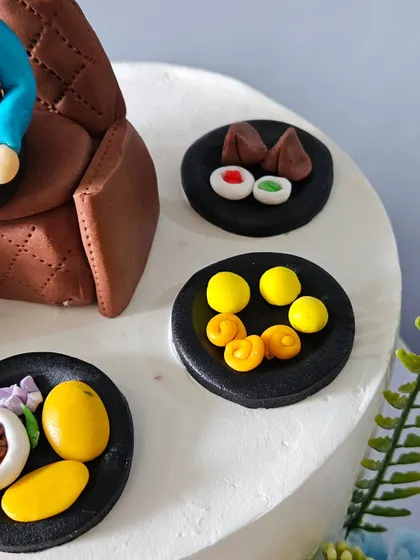 A detailed shot of the miniature edible Indian sweets and snacks I created for the dad's retirement cake. You can see the texture and color work on the tiny samosas, laddoos, and other treats.