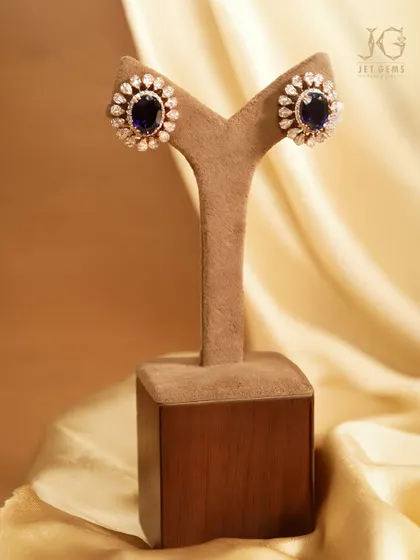 Inspired by the moonlit sky. A halo of diamonds surrounds a deep blue sapphire in these radiant stud earrings, a timeless addition to any jewellery collection.
