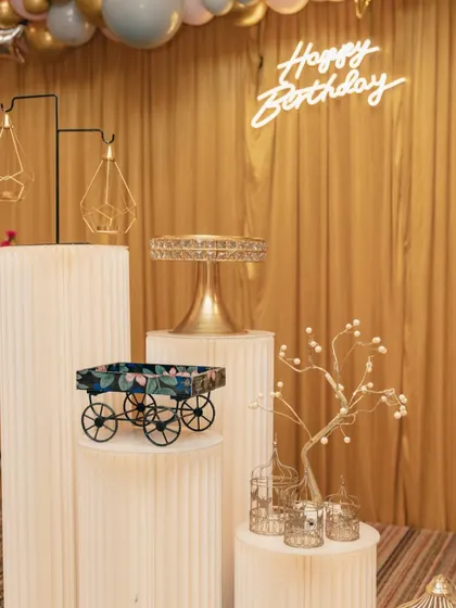 We use a variety of props to enhance the decor. For this party, we used corrugated plinths of different heights, a miniature cart, and delicate birdcages to display desserts and decorative items.