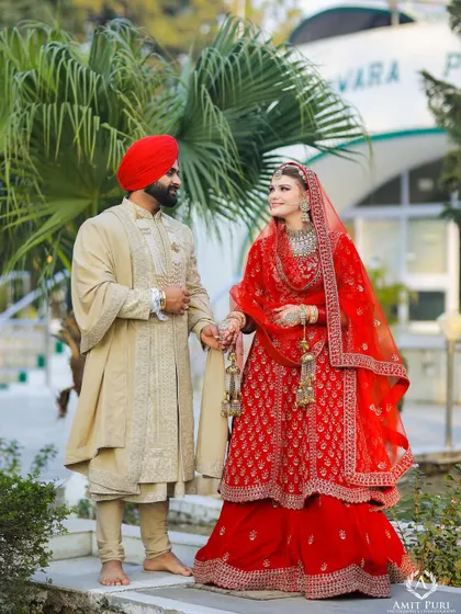 A full-length portrait of a Sikh couple outside the Gurudwara. Their traditional attire and the serene setting create a beautiful and respectful image of their union.
