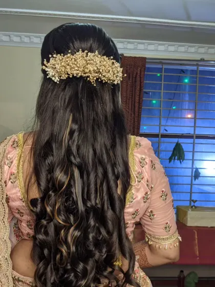 A half-up style with curls, featuring a large, gold-toned baby's breath accessory.