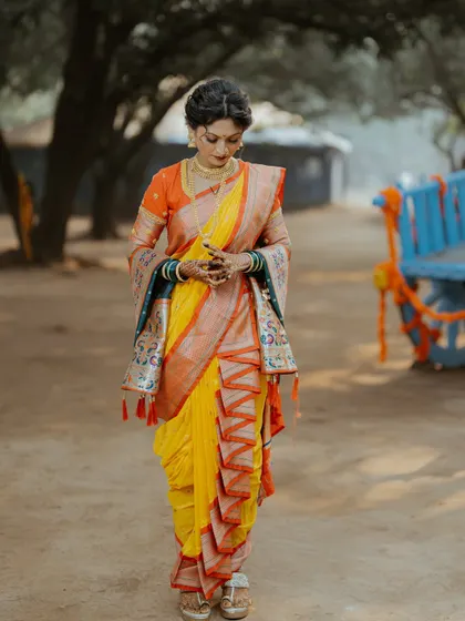 A moment of quiet elegance. This full-length shot captures the unique zig-zag drape of the Nauvari saree, a style that is both traditional and eye-catching.