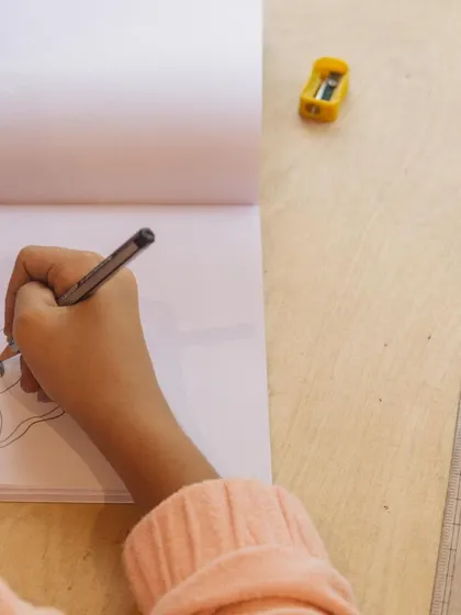 The focused hand of a young artist at work. It's in these quiet moments of concentration that creativity blossoms.