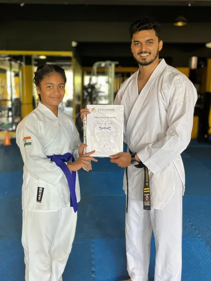 A student receives her certificate, a tangible reward for her hard work and dedication to karate.