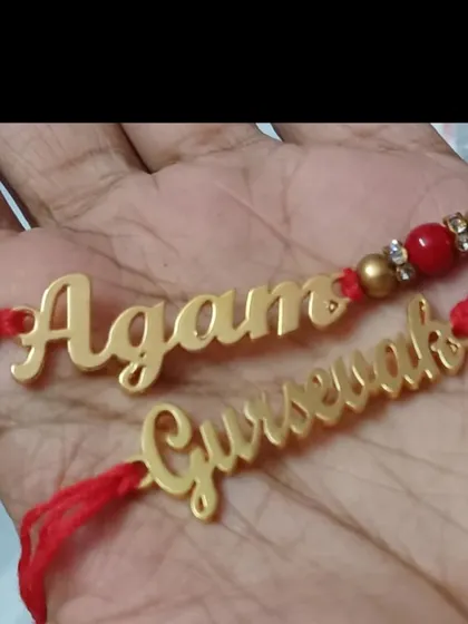 Another example of my custom-cut name rakhis, held in hand to show their size and detail.