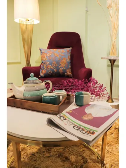 A cozy corner featuring a luxurious maroon armchair, perfect for reading, placed next to a stylish coffee table.