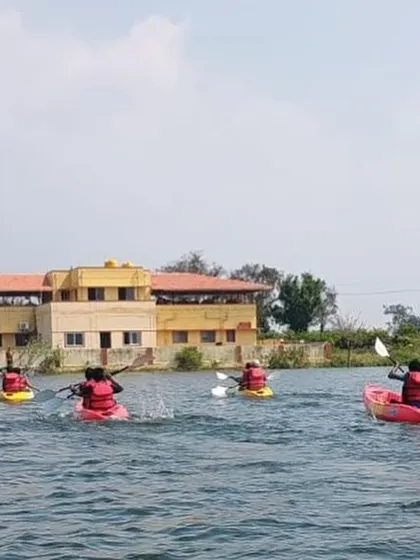 Kayakers paddle towards our training center in Ambigarahalli after a session on the water.