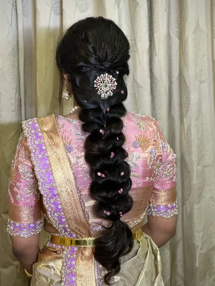 A voluminous and textured modern braid, perfect for a reception or sangeet. The style is accented with a beautiful jeweled clip for a touch of sparkle.