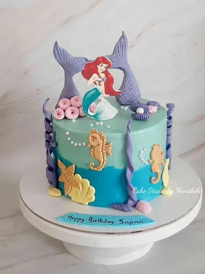 A mermaid themed cake for Sapna, made with minimal fondant. The design has a beautiful Ariel, mermaid tails, and other details from under the sea.