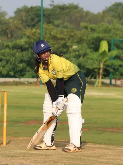 A batter watches the ball intently after playing a shot, set against the backdrop of our green ground.