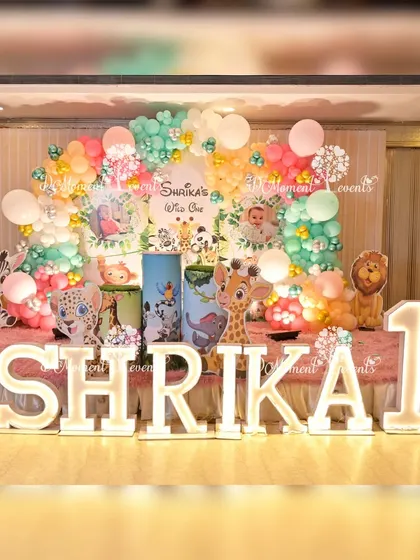 Let's get wild for a "Wild One" jungle-themed first birthday. This setup features a lush backdrop, friendly animal cutouts, and personalized light-up letters, all designed to create a fun and adventurous safari atmosphere for your little explorer.