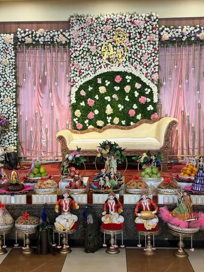 A beautiful platter setup with musician dolls and a floral backdrop for an elegant event.