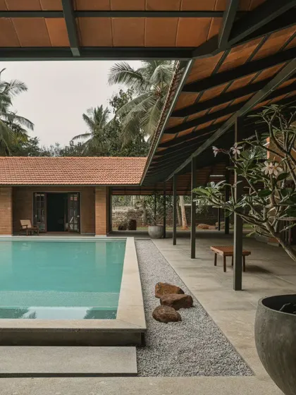A long shot of the pool and covered patio, showing how the different wings of the villa are connected. The design prioritizes easy movement between the private rooms and the shared outdoor leisure spaces.