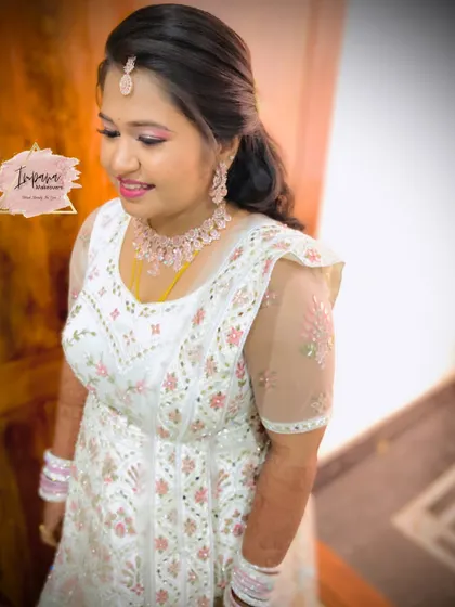 A gorgeous bride in a white and pink Anarkali for her reception. I created a fresh, dewy makeup look with a pop of pink on the lips to match her elegant outfit.