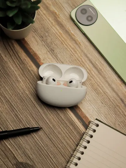 A close up shot of realme earbuds on a wooden desk, creating a warm and professional workspace vibe.